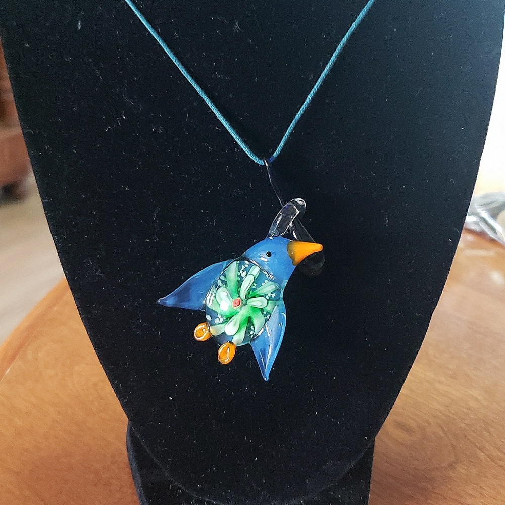 Glass bird pendant with adjustable string.